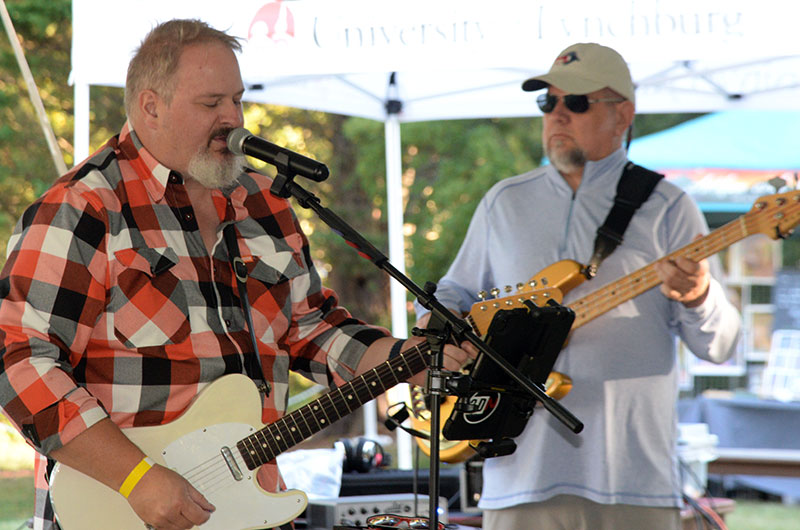 Two musicians that are playing guitars